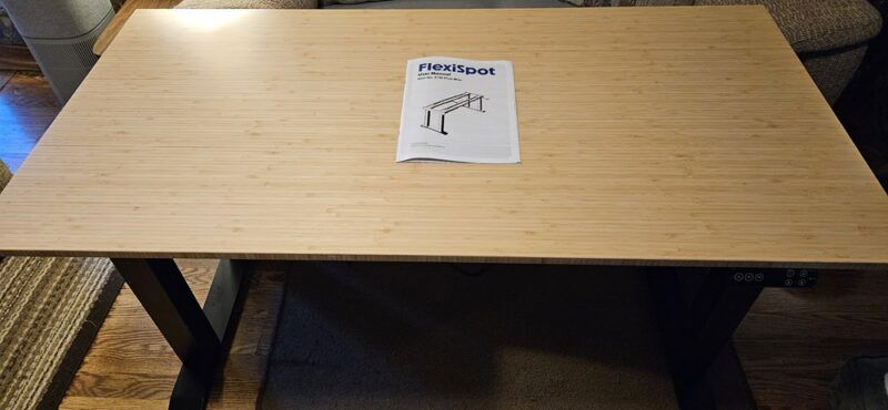 FlexiSpot desk with instructions on top.