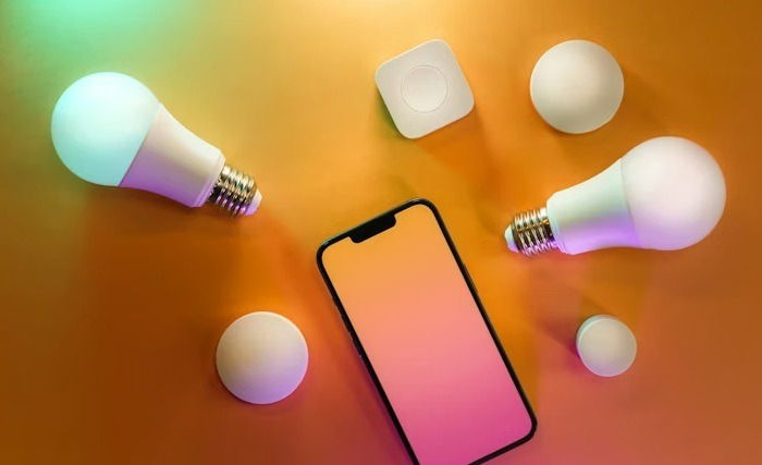 Smart bulbs next to a phone.